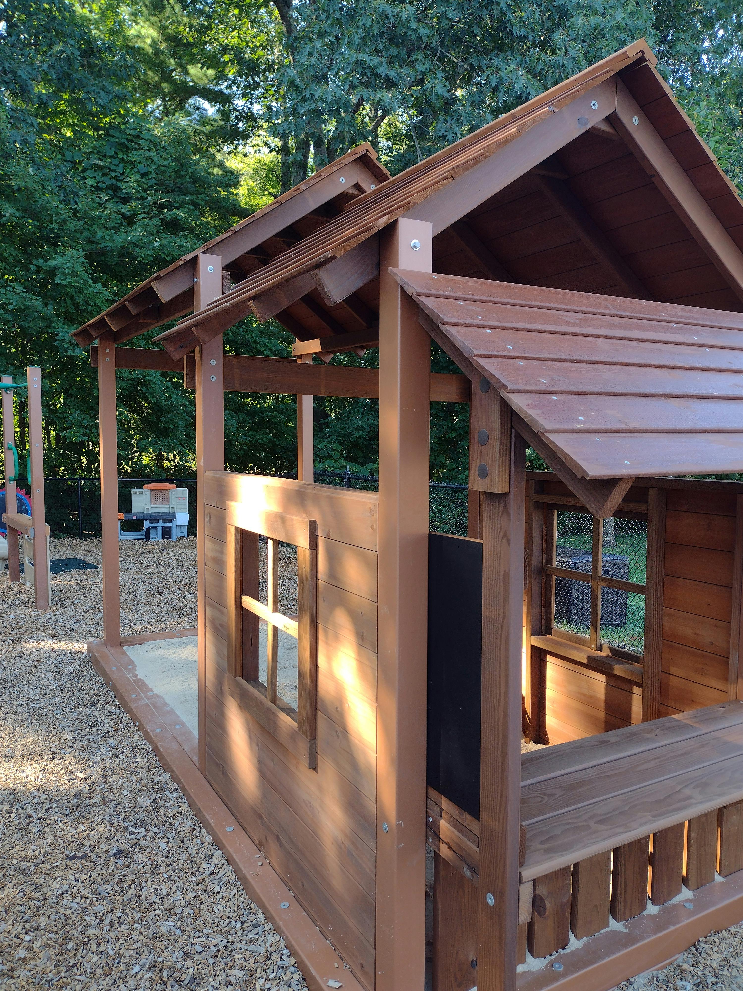 Wooden playhouse with a window and a small counter
