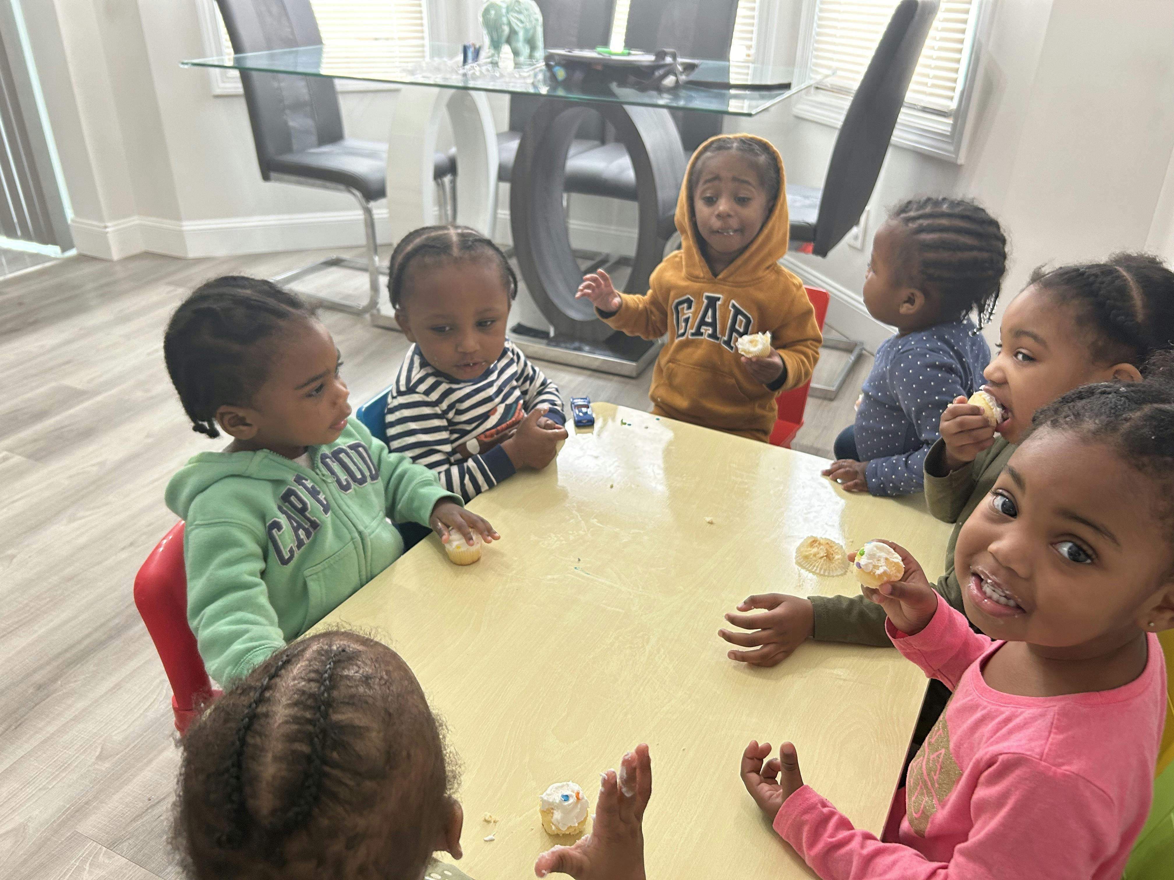 Group of children eating cupcakes at a table