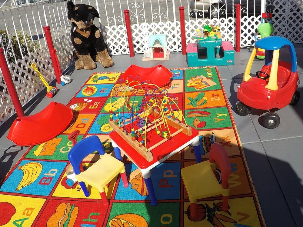 Play area with a colorful alphabet rug and various toys