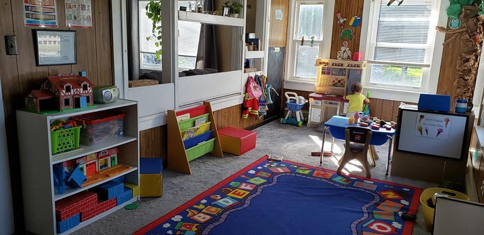 Child standing at a table in a playroom