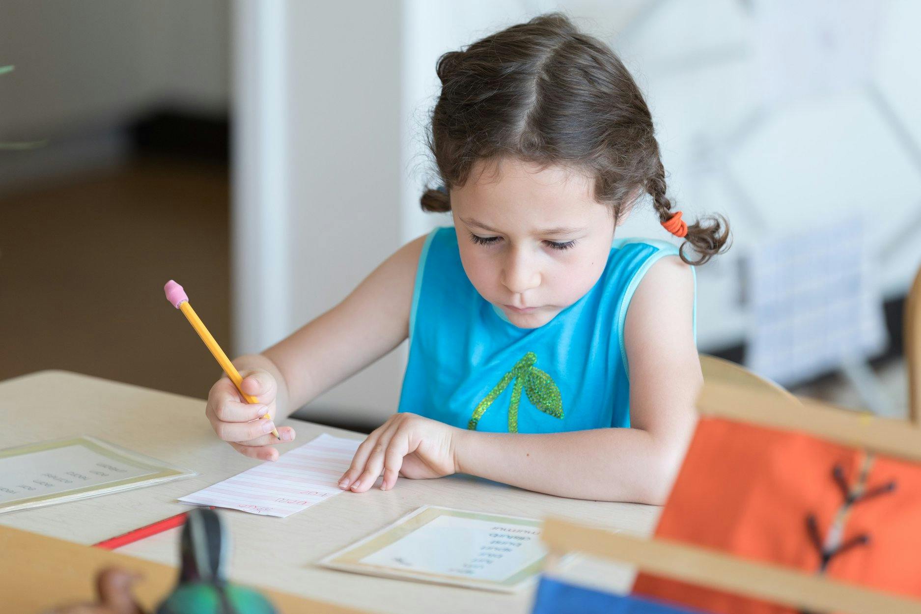Child writing on paper at a desk