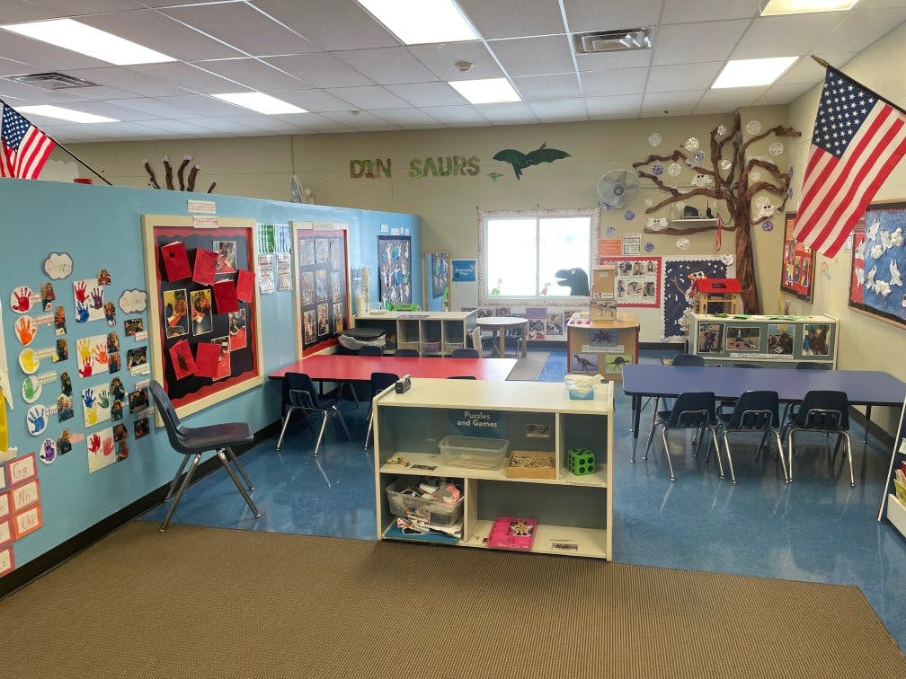 A classroom with tables, chairs, and bulletin boards with student artwork