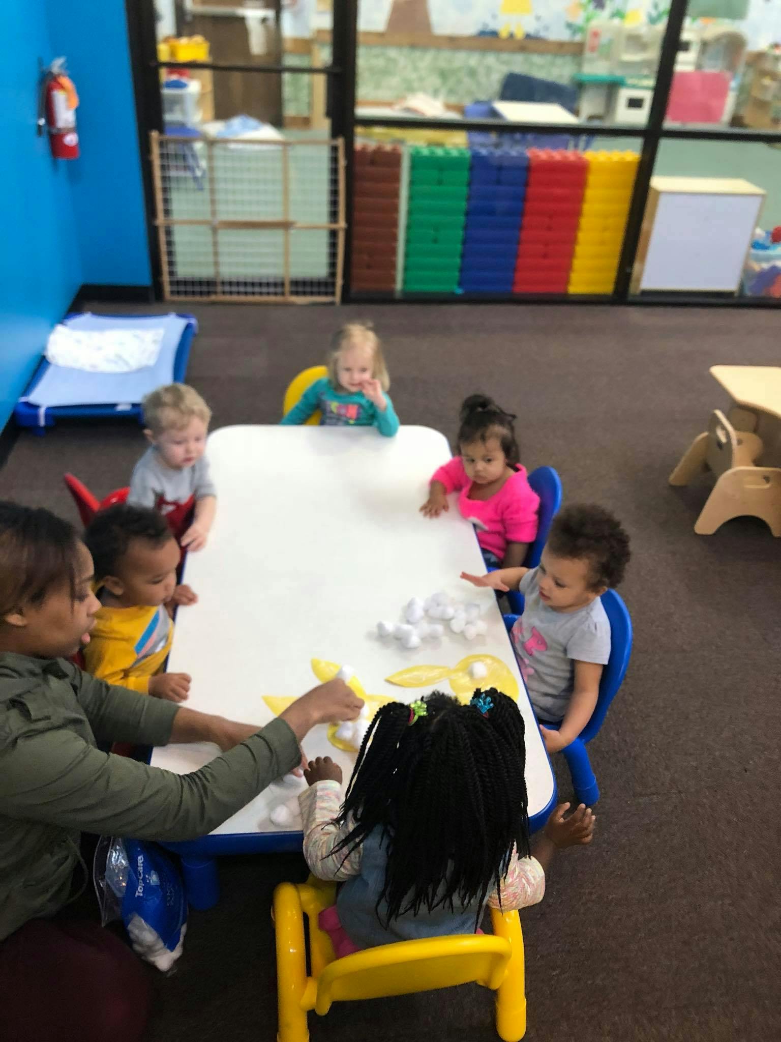 Adult and children at a table with craft supplies