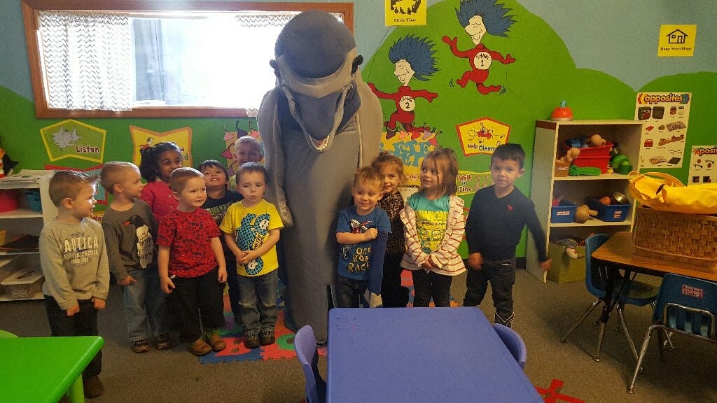 Person in costume with children in a classroom