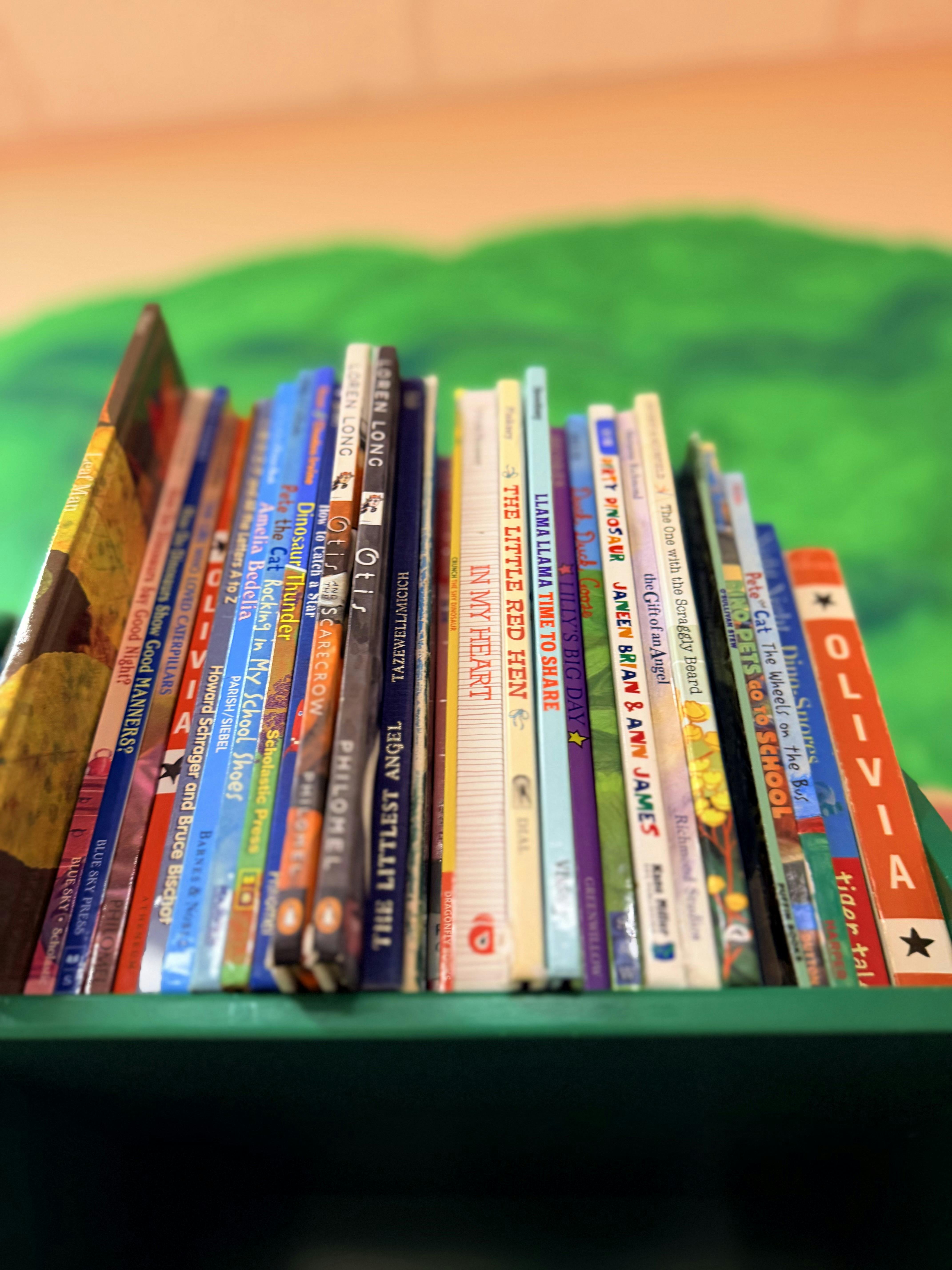 A row of children picture books lined up on a shelf