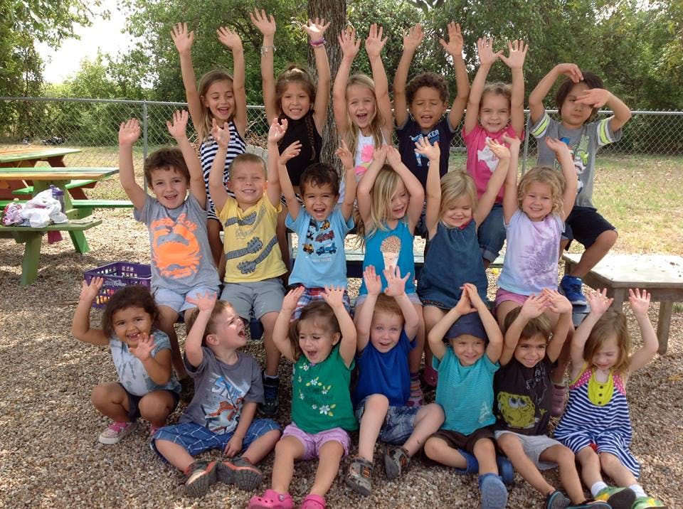 Group of children raising their hands outdoors