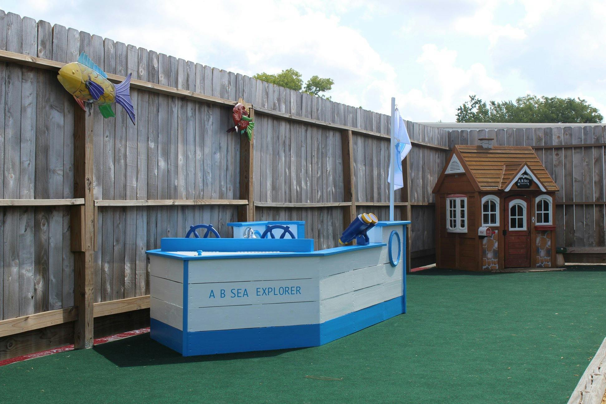 Play area with a boat structure and a small playhouse