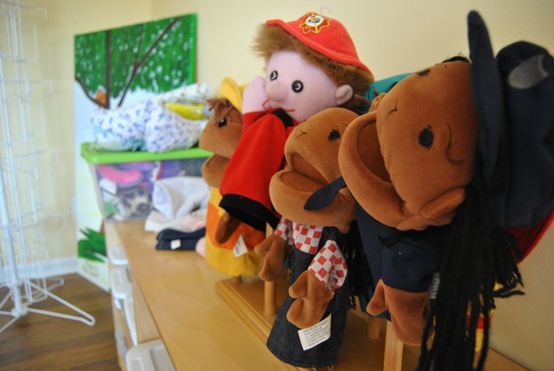 Row of various hand puppets on a wooden surface