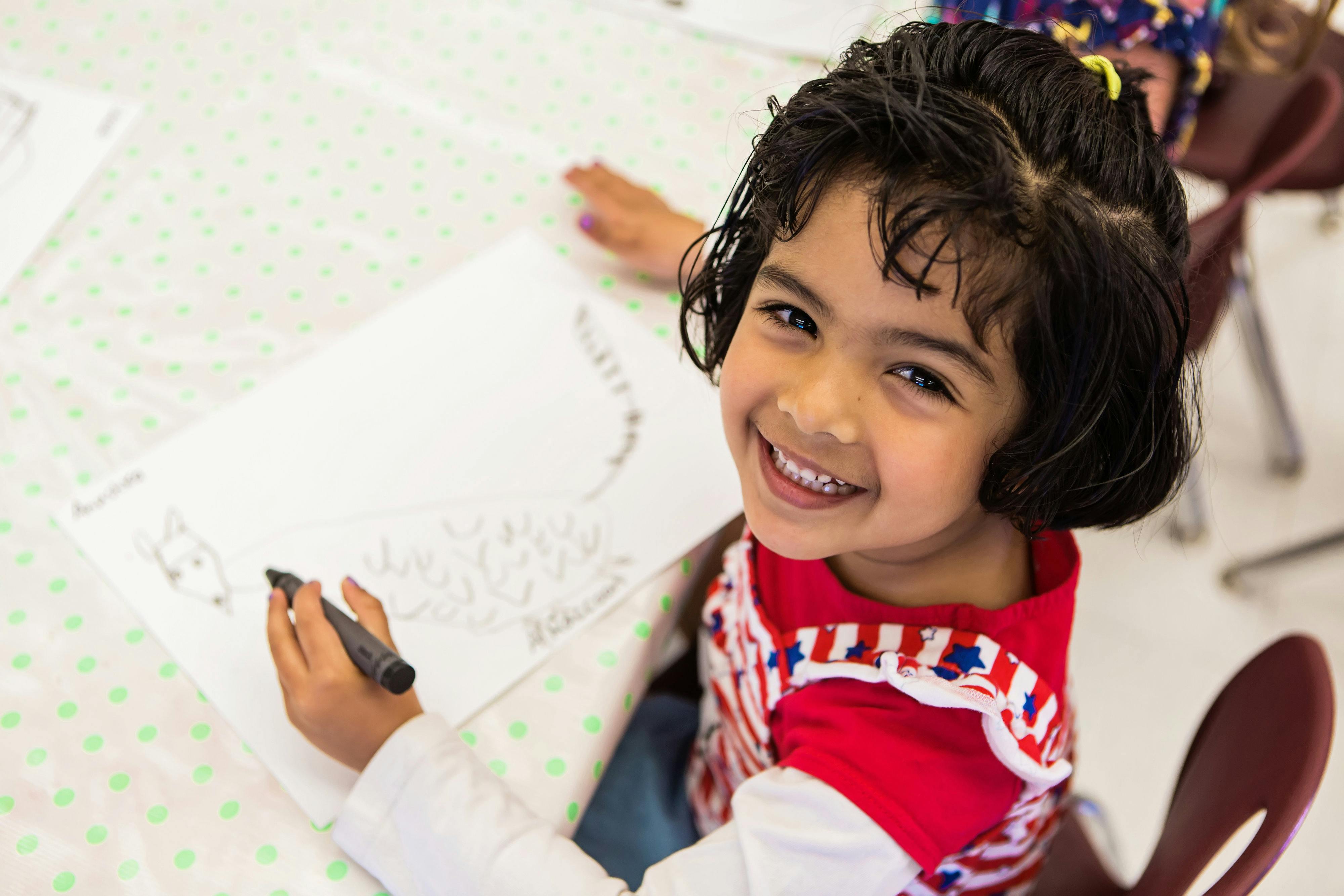 Child drawing on paper with a marker