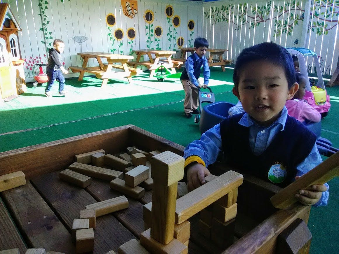 Child playing with wooden blocks in a play area
