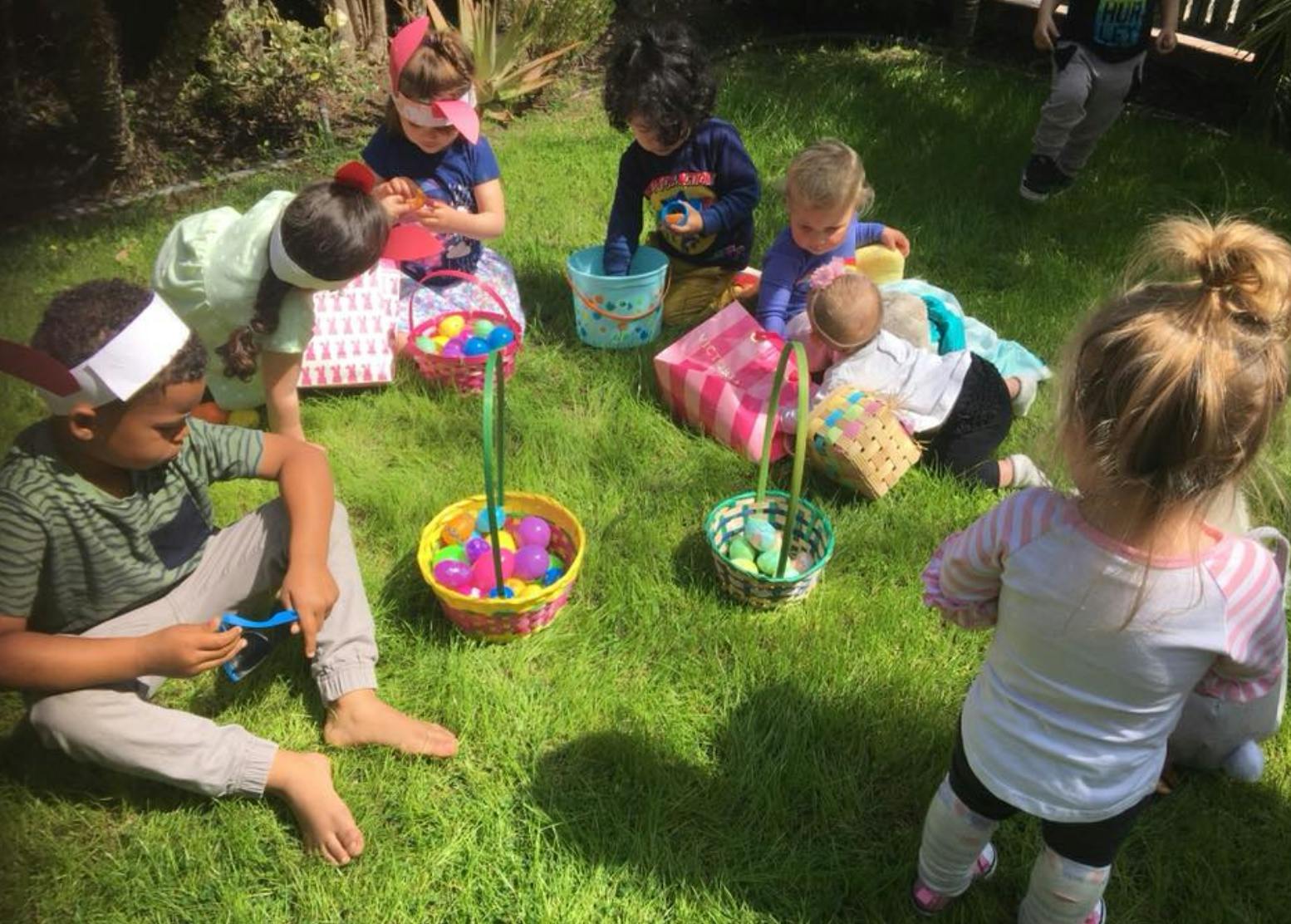 Children on grass with baskets and colorful eggs