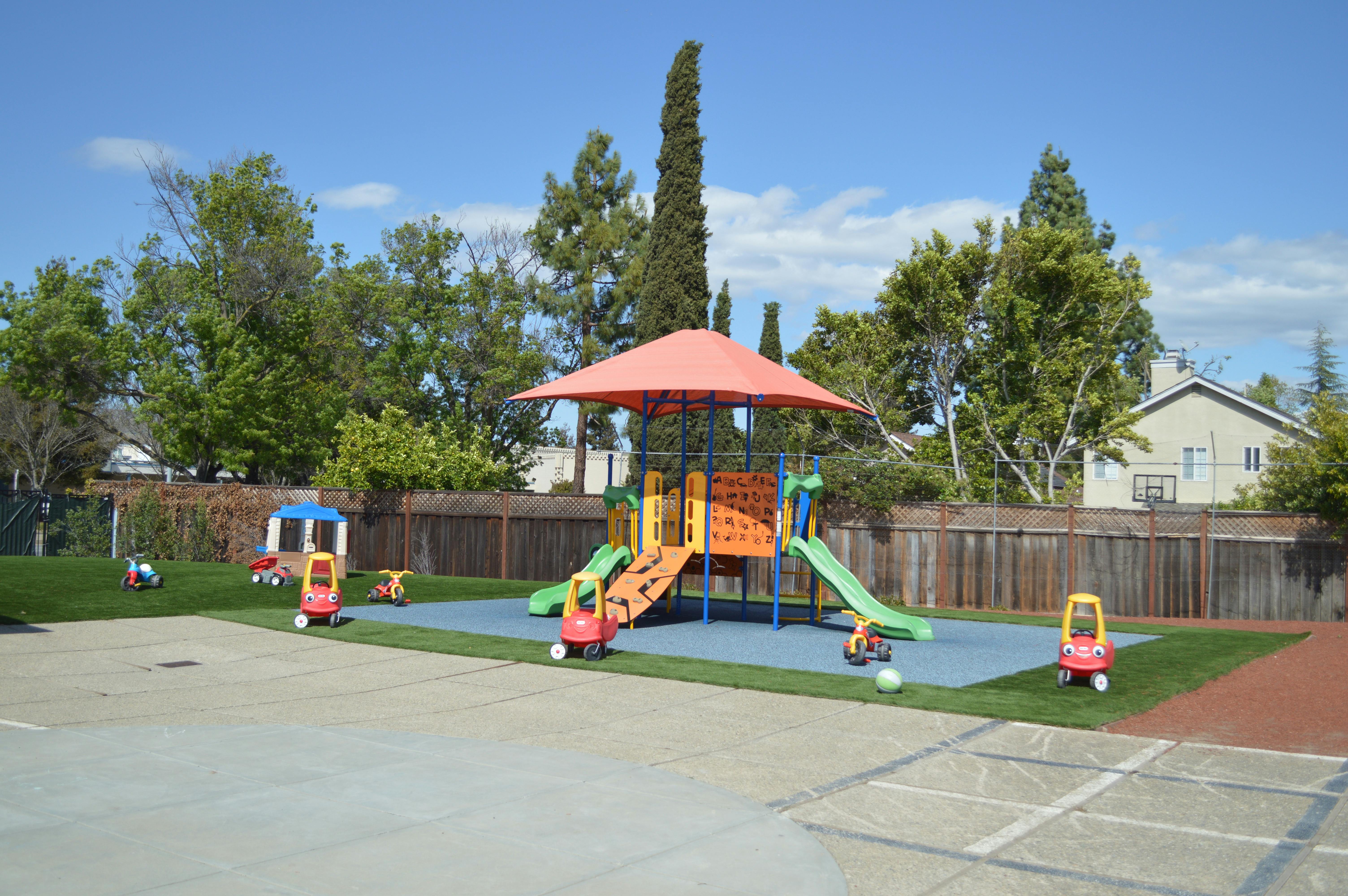 Playground with slides, climbing structure, and small ride-on toys