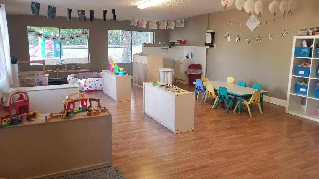 Playroom with small tables and chairs, toys, and storage shelves