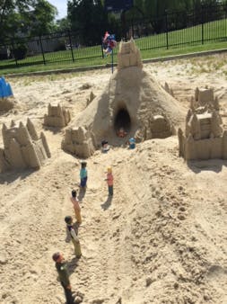 Sandcastle with small figures around it