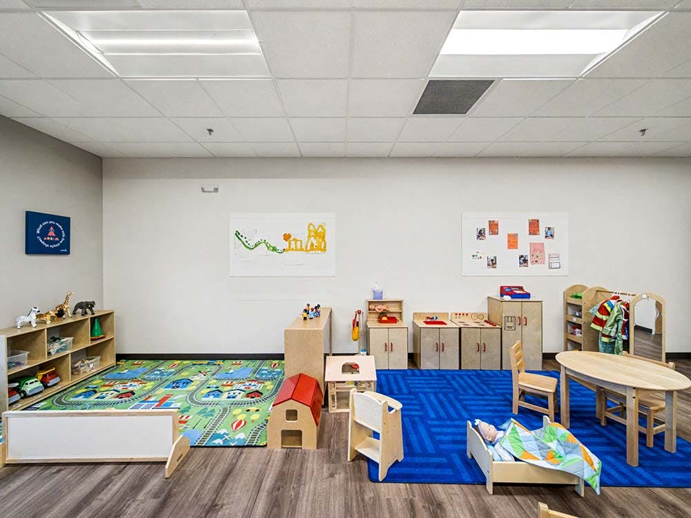Empty children's playroom with small furniture and colorful rugs