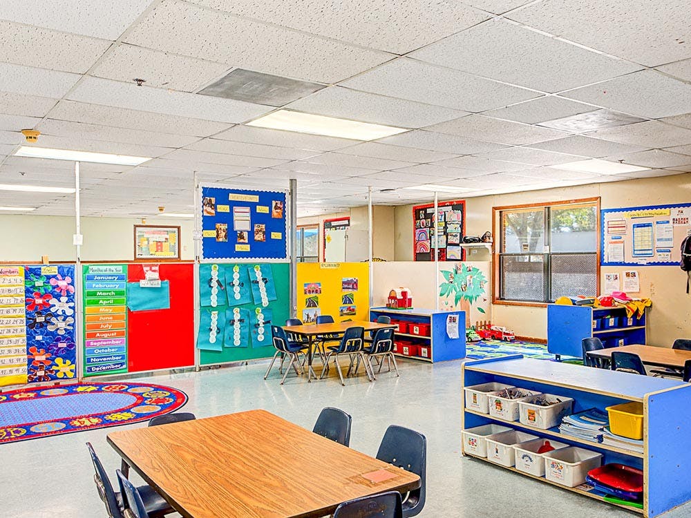 Empty colorful children's classroom with small tables and chairs