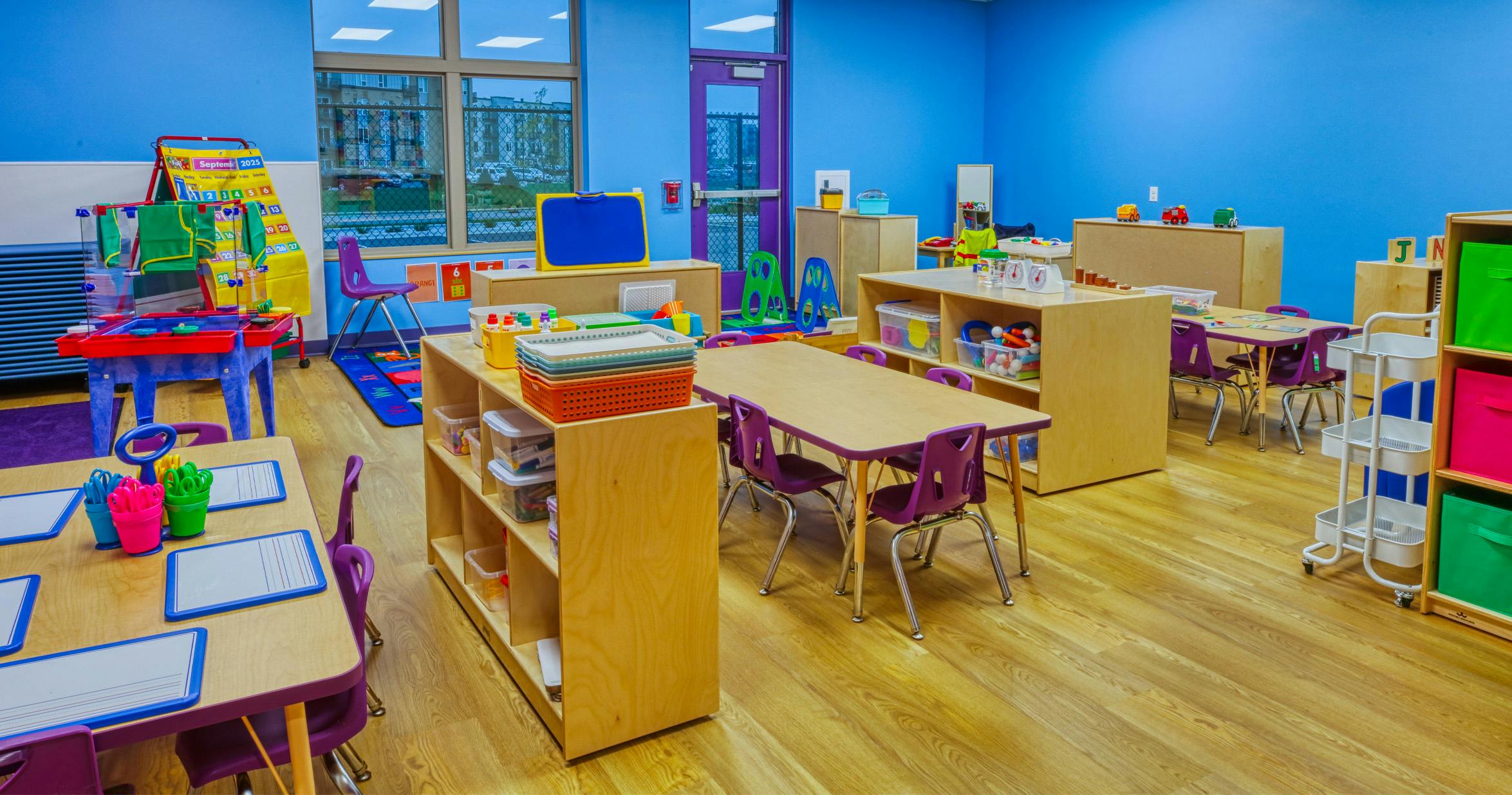 Empty classroom with tables, chairs, and shelves