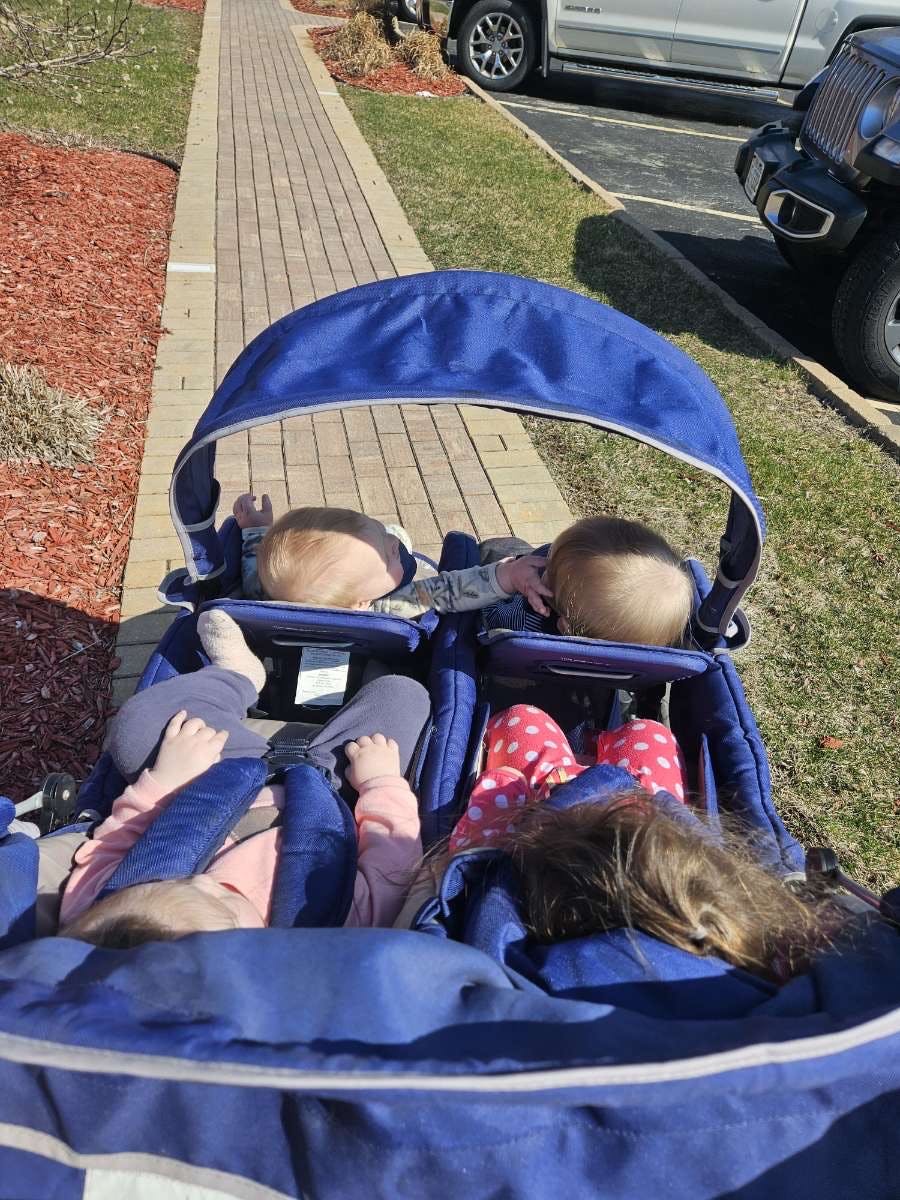 Two children in a blue double stroller