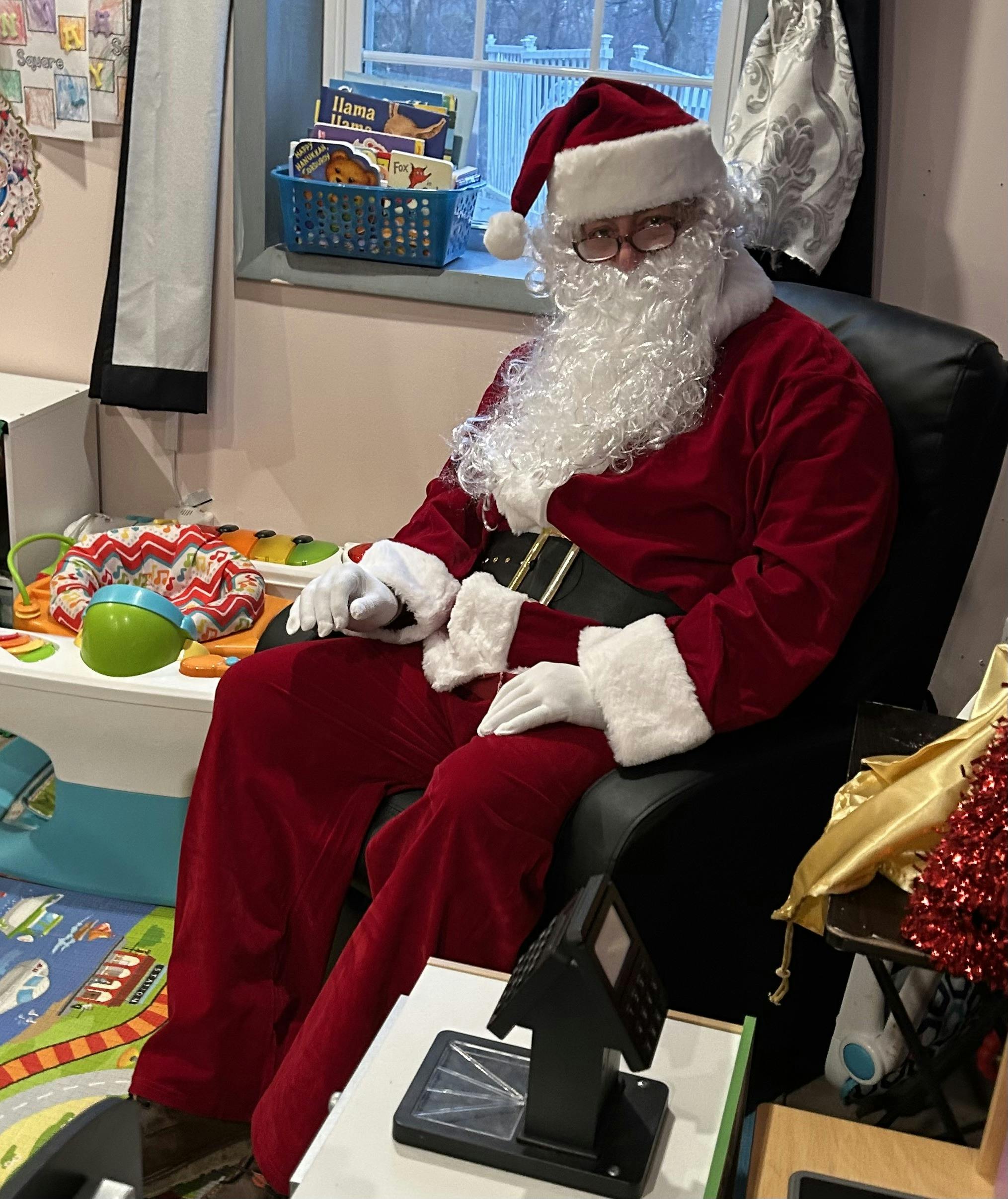 Person dressed as Santa Claus sitting in a chair