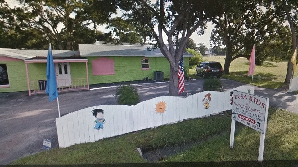 Green building with a white fence decorated with cartoon characters
