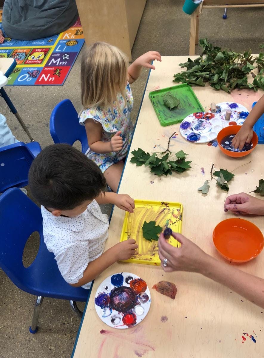 Children doing leaf art at a table