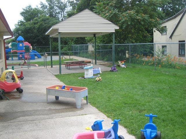 Playground area with various toys, sand and water table, and a covered picnic table