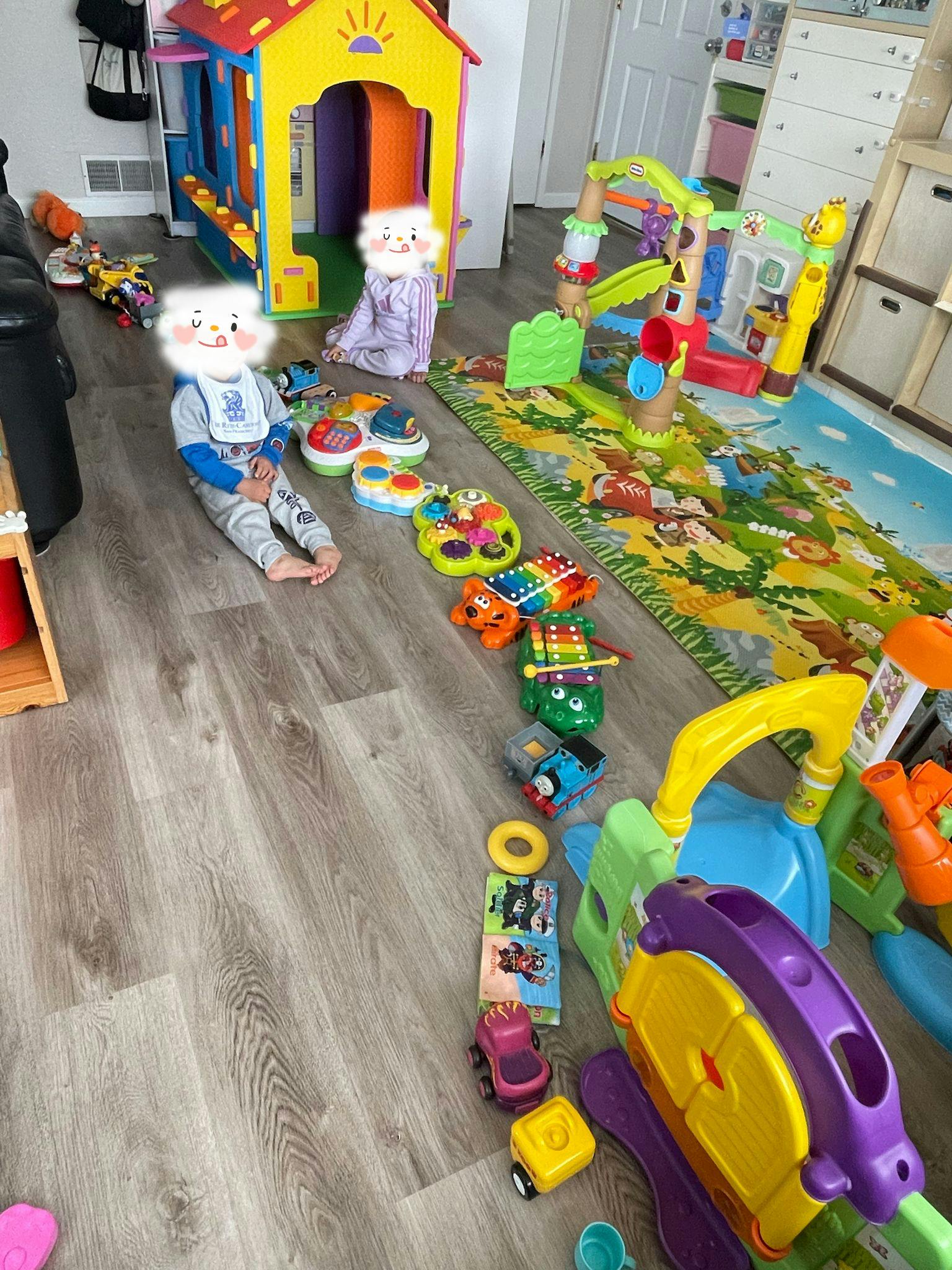 Two children playing with toys on a wooden floor
