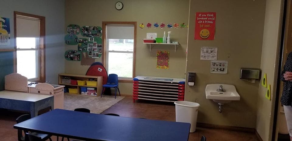 Classroom with small tables, chairs, and a sink