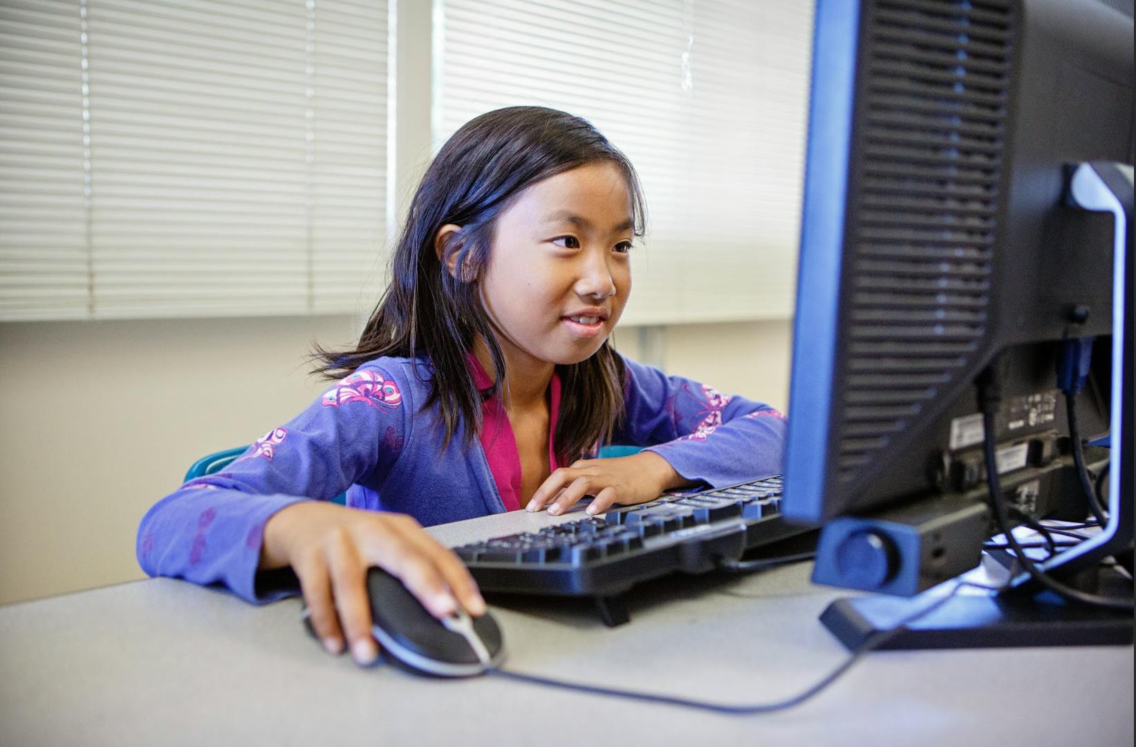 Child using a computer mouse and keyboard