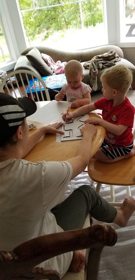 Person and two children drawing at a table