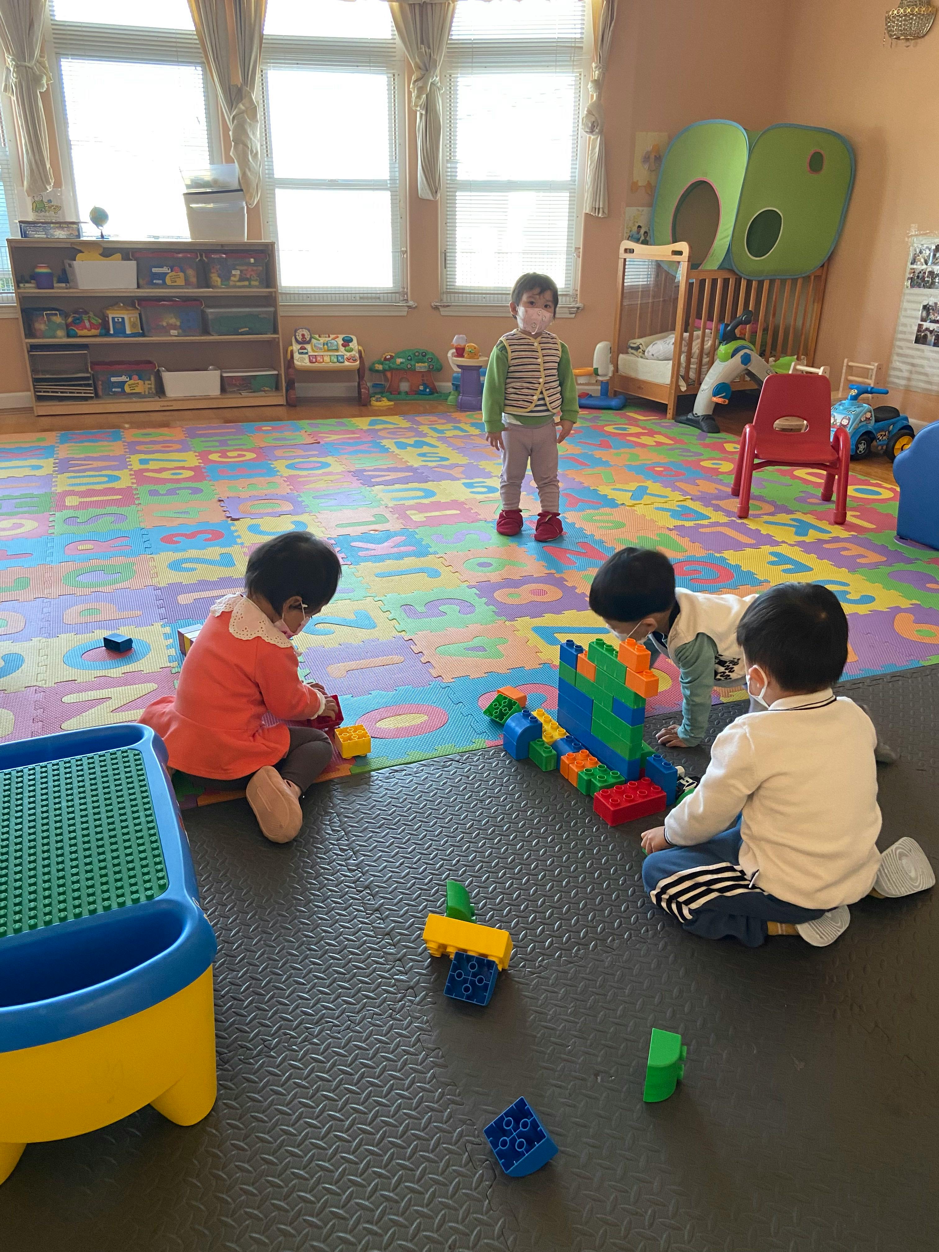 Three children playing with building blocks in a classroom