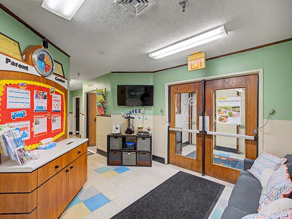 Entryway with a red bulletin board, a coffee station, and double doors