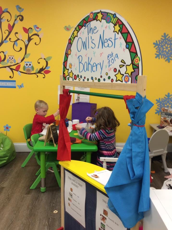 Two children playing at a small table in a classroom