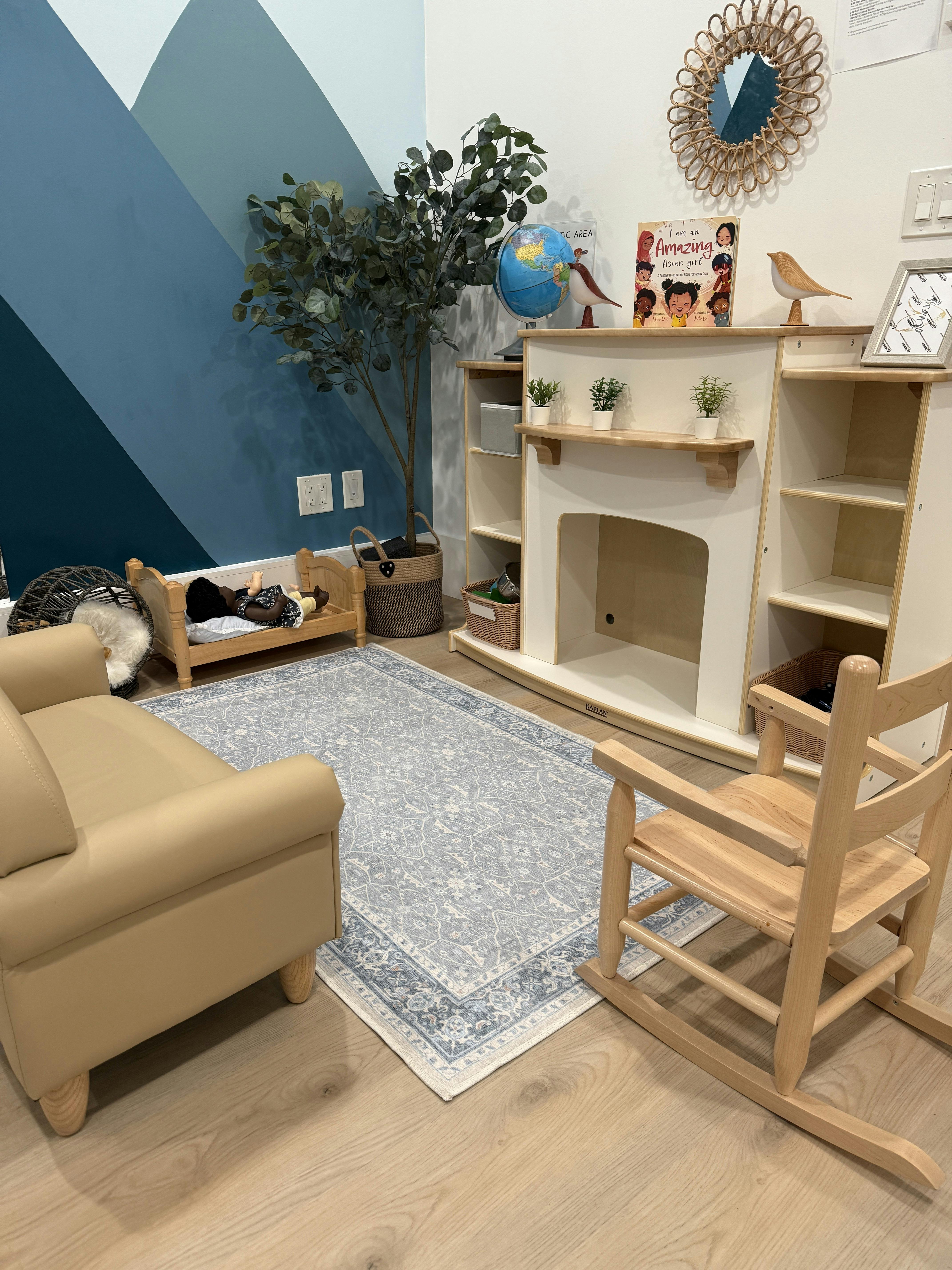 Playroom with a small couch, rug, and toy fireplace