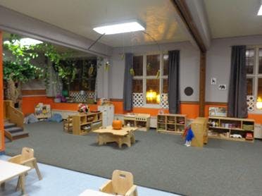 Empty classroom with small tables and shelves