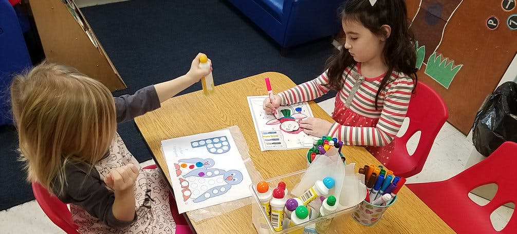Two children doing crafts at a table