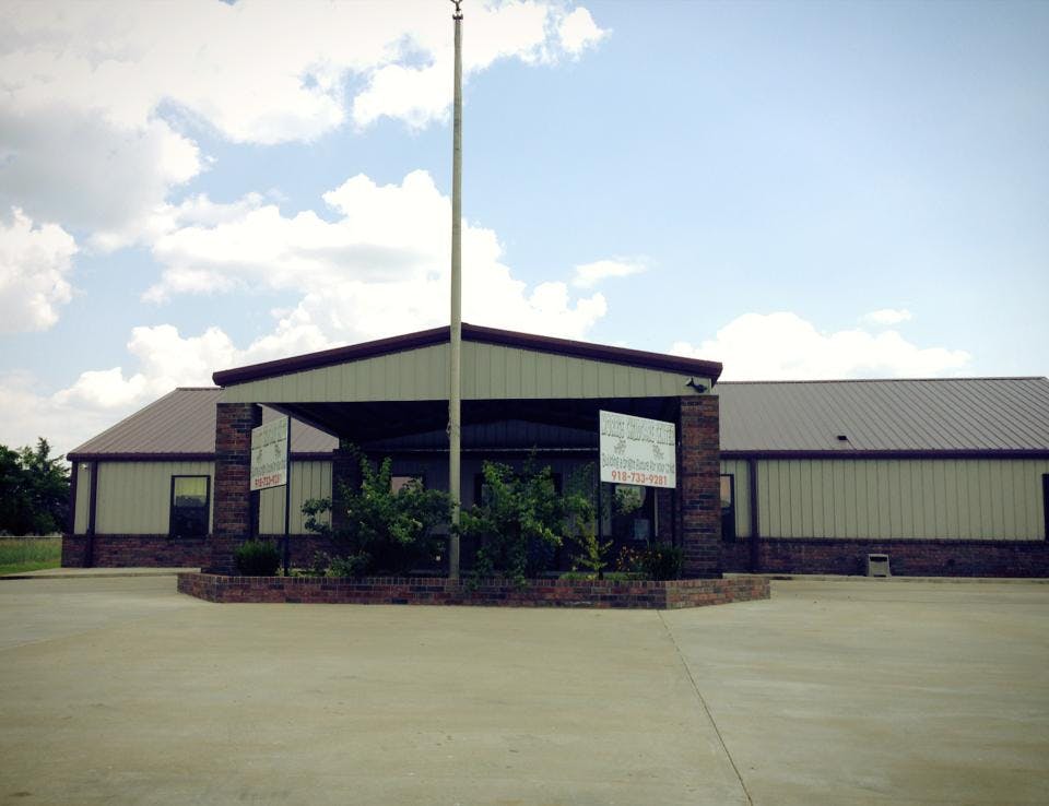 Building with a covered entrance and a flagpole in front