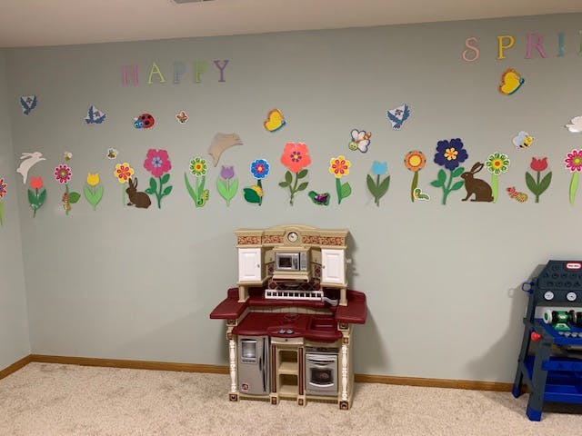 Play kitchen and wall decorated with flowers and animals