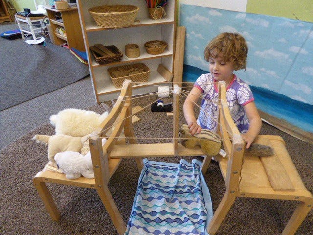 Child weaving on a loom in a classroom