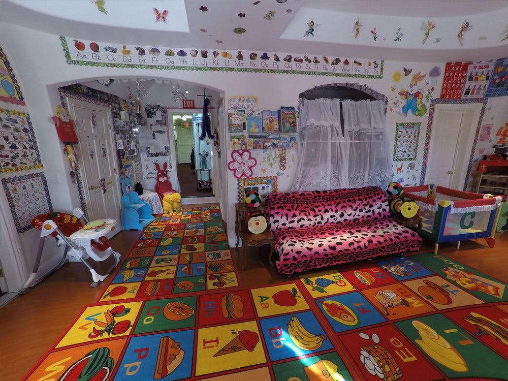 Playroom with colorful alphabet rug, sofa, and crib