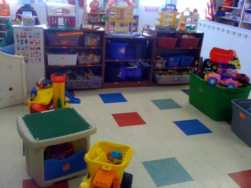Playroom with toys, shelves, and colorful floor squares
