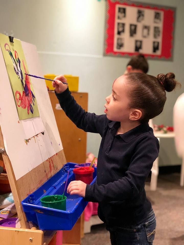Child painting on an easel