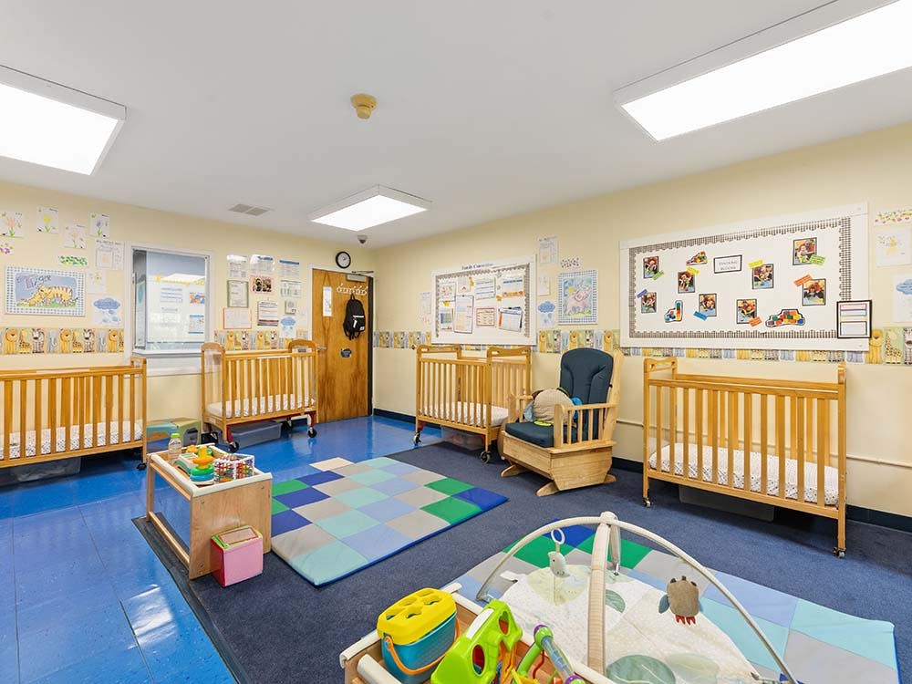 Baby room with multiple cribs and play areas