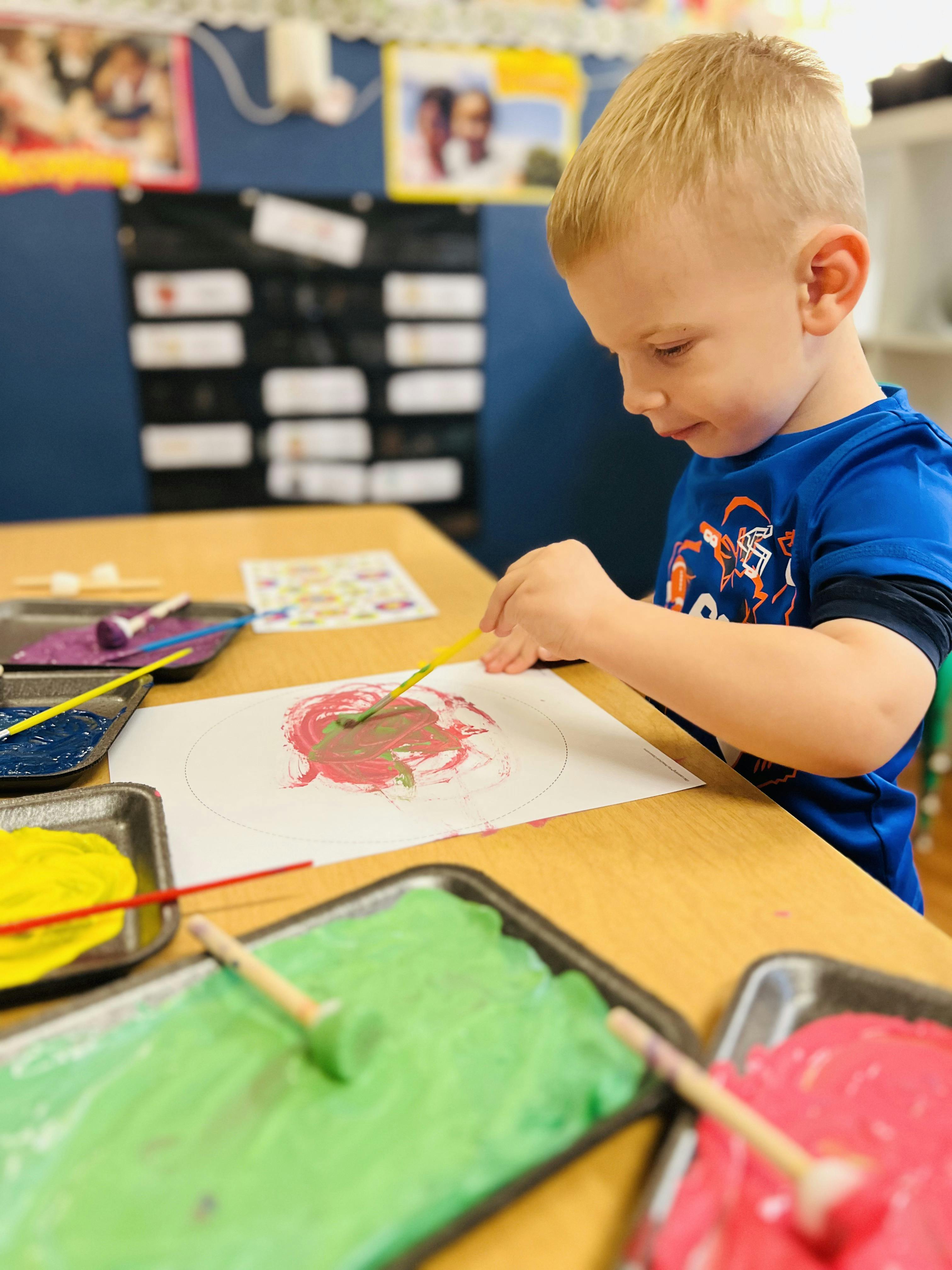 Child painting on paper at a table