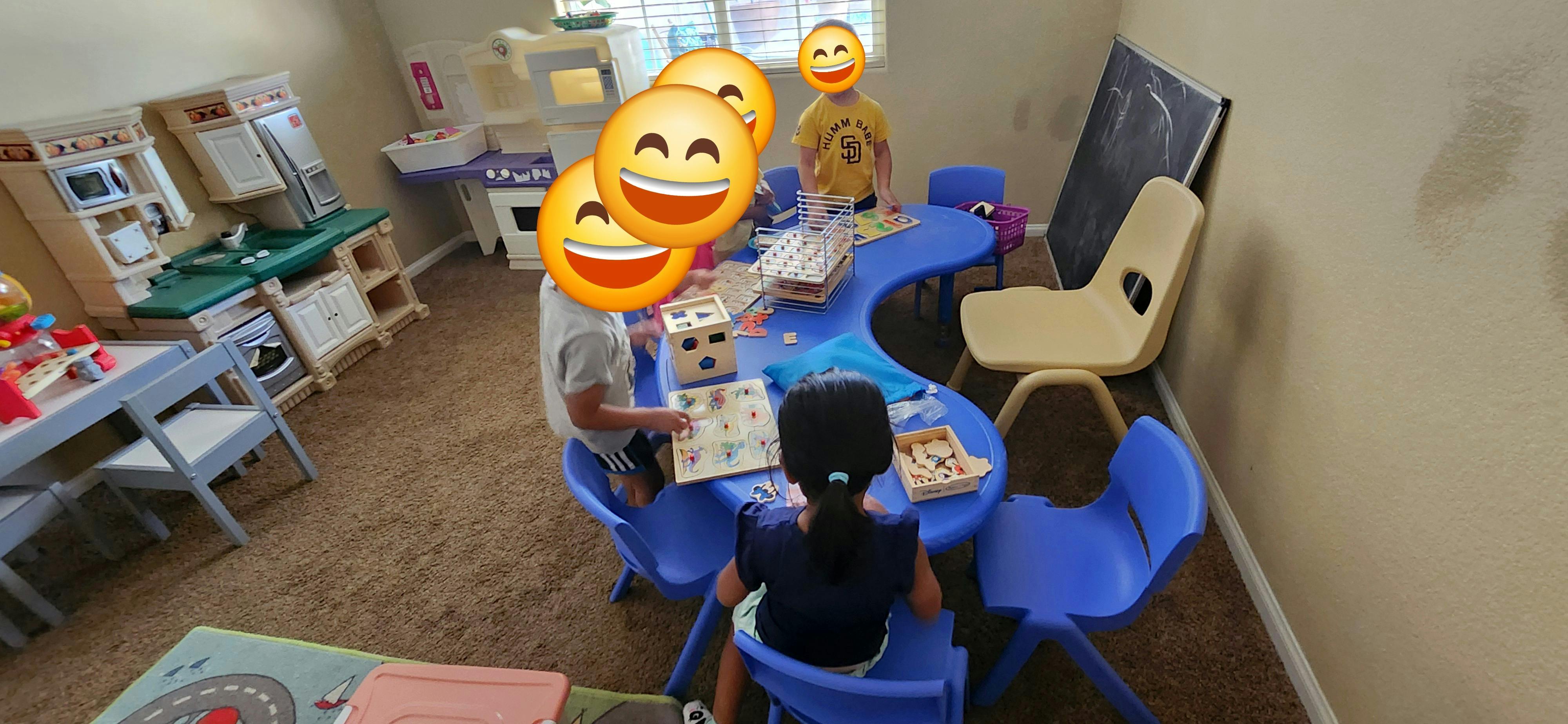 Children sitting at a blue table with books in a classroom