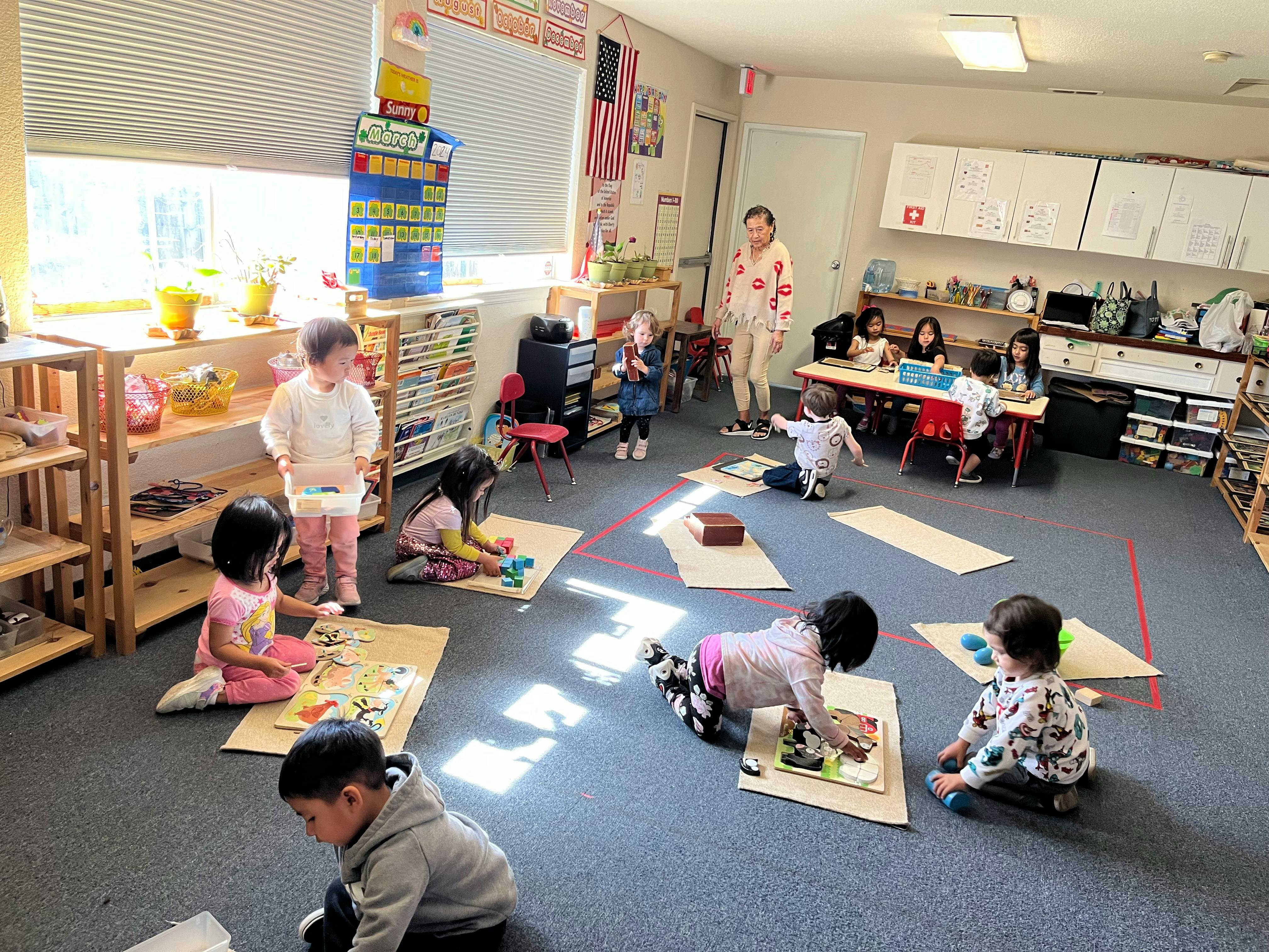 Children playing with toys on the floor in a classroom