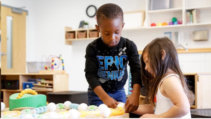 Two children playing with toys at a table