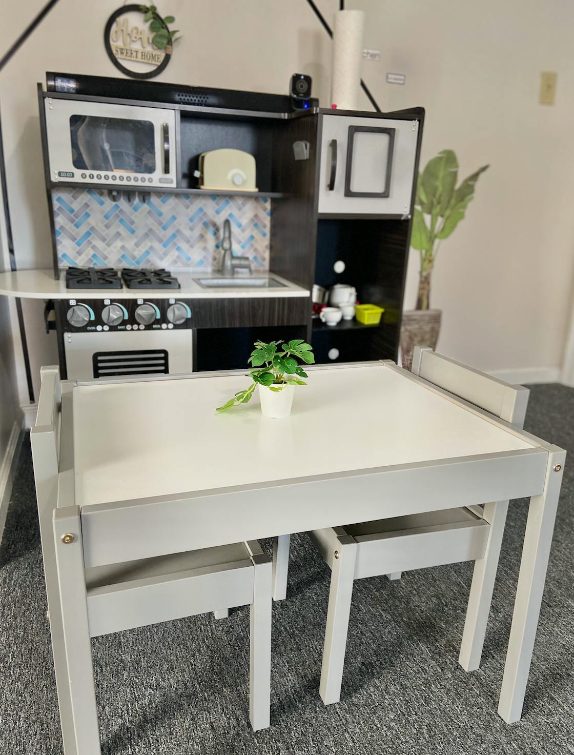 Child's play kitchen with a small table and chairs