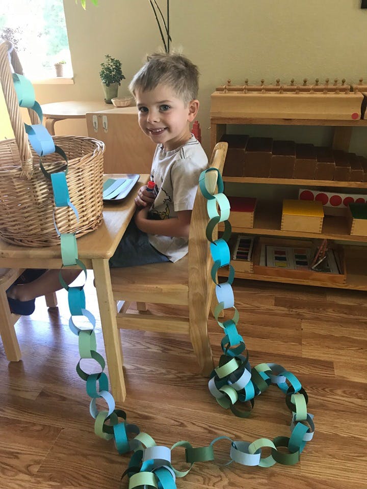 Child sitting at a table with a paper chain