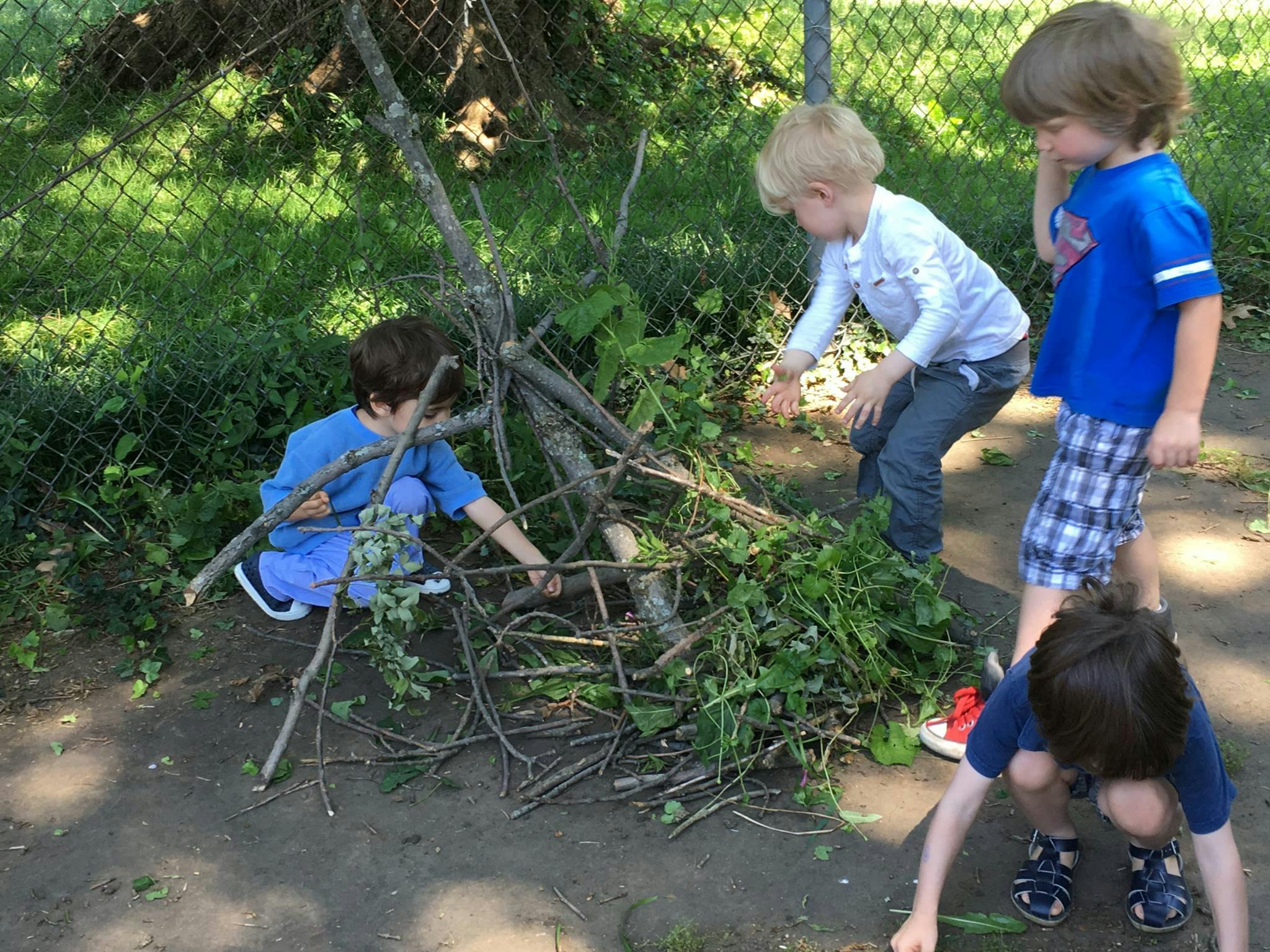 Children playing with sticks and leaves outdoors